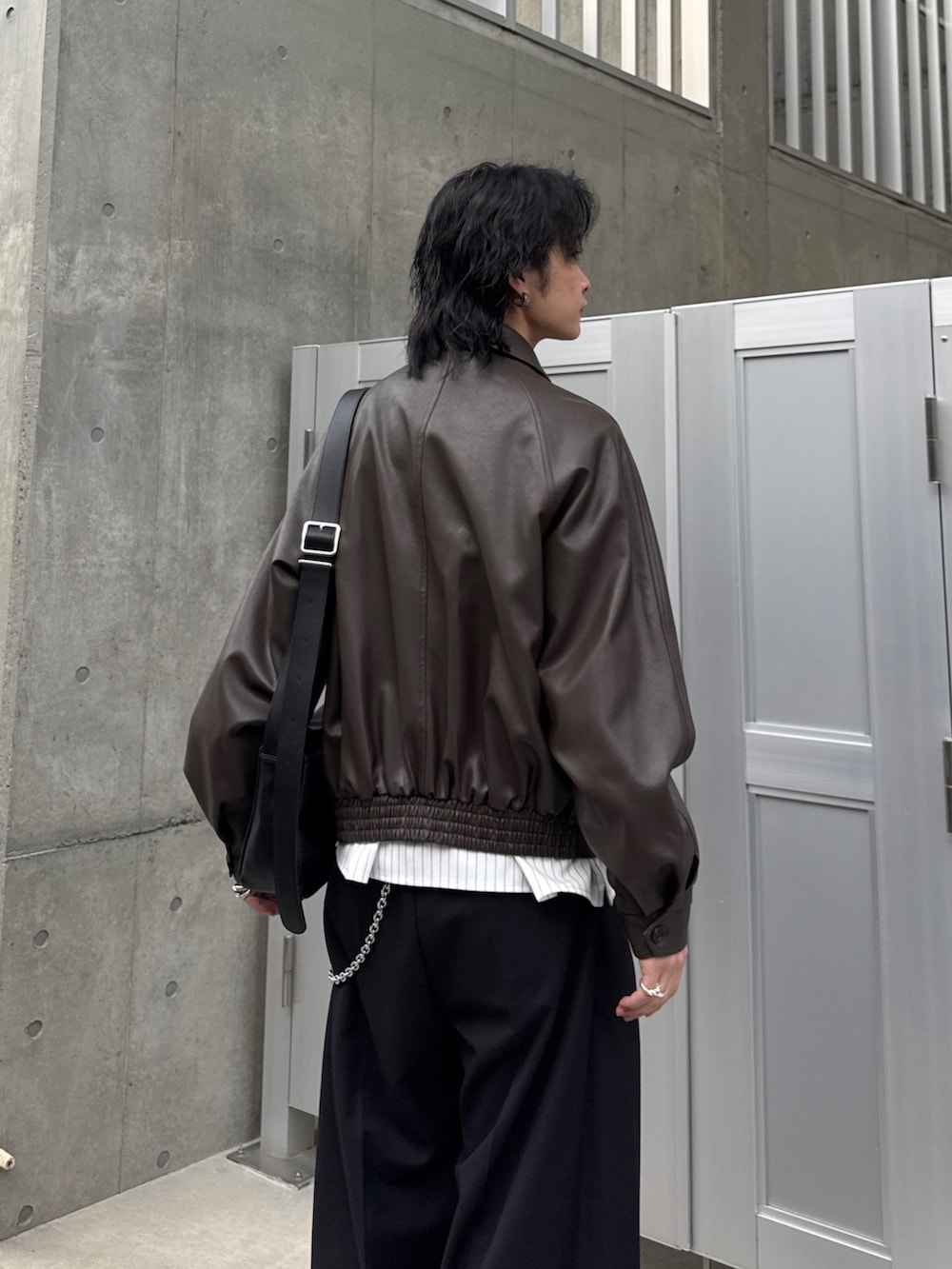 ブラウン系のブルゾン、ホワイト系のシャツ/ブラウス、ブラック系のスラックスを着用したメンズの春コーディネートの5枚目の写真