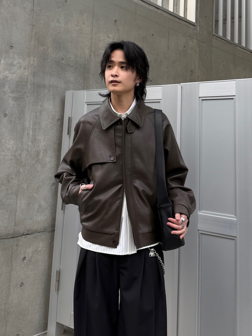 ブラウン系のブルゾン、ホワイト系のシャツ/ブラウス、ブラック系のスラックスを着用したメンズの春コーディネートの3枚目の写真