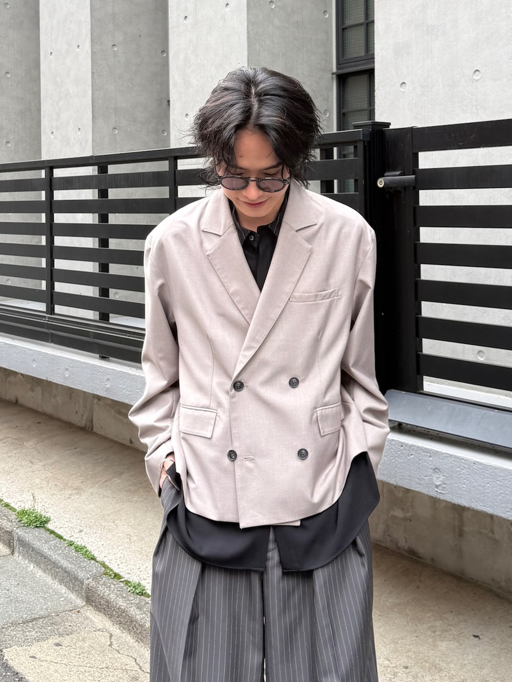 グレー系のスラックス、グレー系のテーラードジャケット、ブラック系のシャツ/ブラウスを着用したメンズの春コーディネートの3枚目の写真