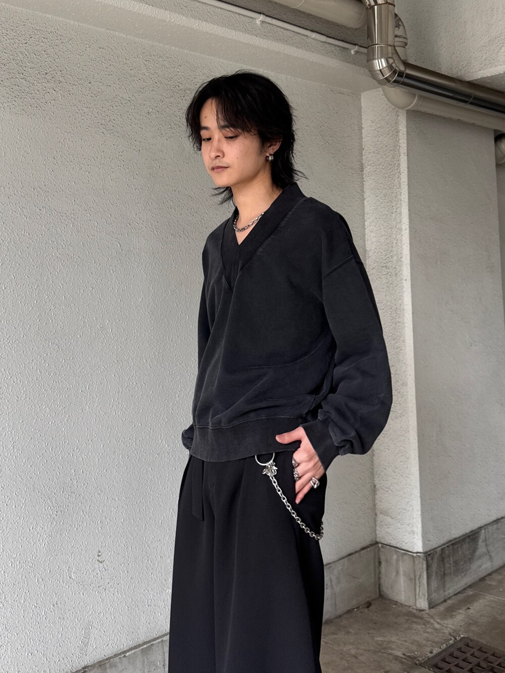 ブラック系のスウェット、ブラック系のスラックス、シルバー系のネックレスを着用したメンズの春コーディネートの5枚目の写真