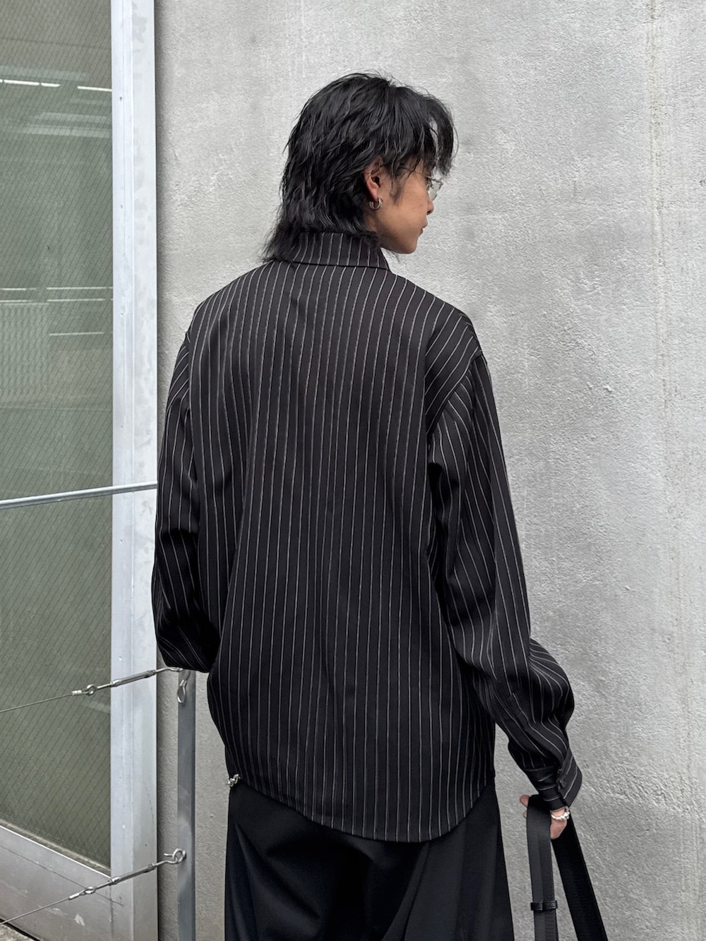 ブラック系のその他パンツ、ブラック系のショルダーバッグ、ブラック系のシャツ/ブラウスを着用したメンズの春コーディネートの6枚目の写真