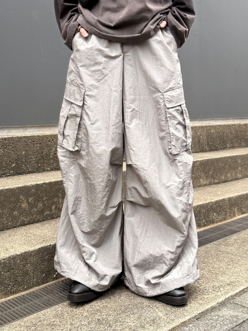 ブラック系のTシャツ/カットソー、グレー系のカーゴパンツ、ブラック系のショルダーバッグを着用したメンズの春コーディネートの7枚目の写真