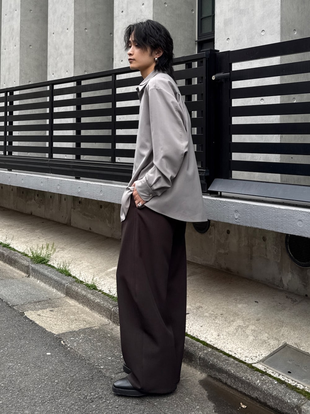 グレー系のシャツ/ブラウス、グレー系のスラックス、ブラック系のショルダーバッグを着用したメンズの春コーディネートの2枚目の写真