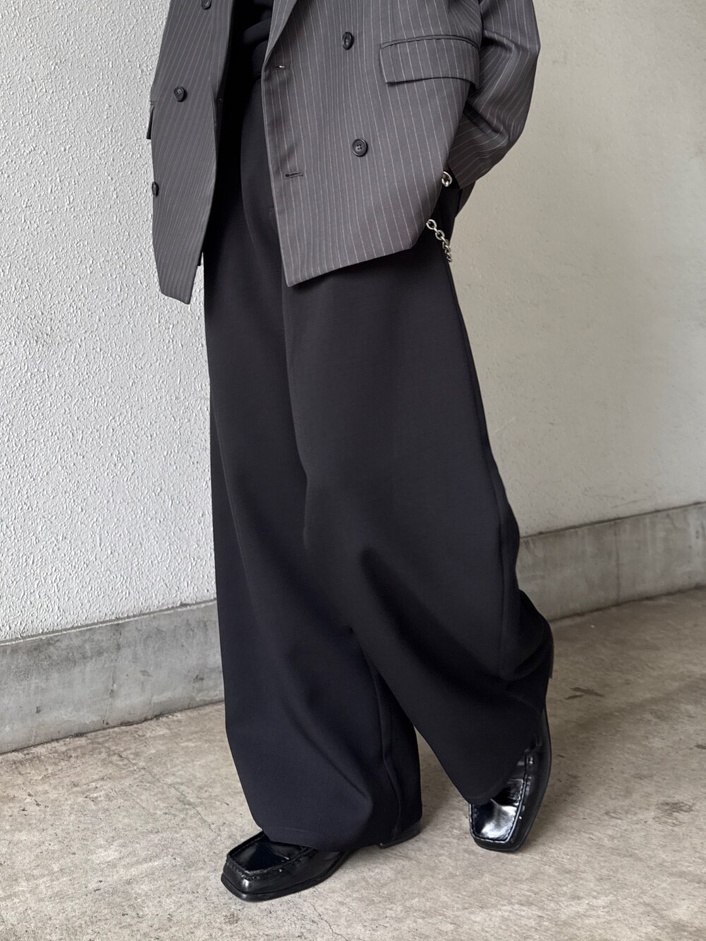 グレー系のテーラードジャケット、ブラック系のTシャツ/カットソー、ブラック系のスラックスを着用したメンズの春コーディネートの10枚目の写真