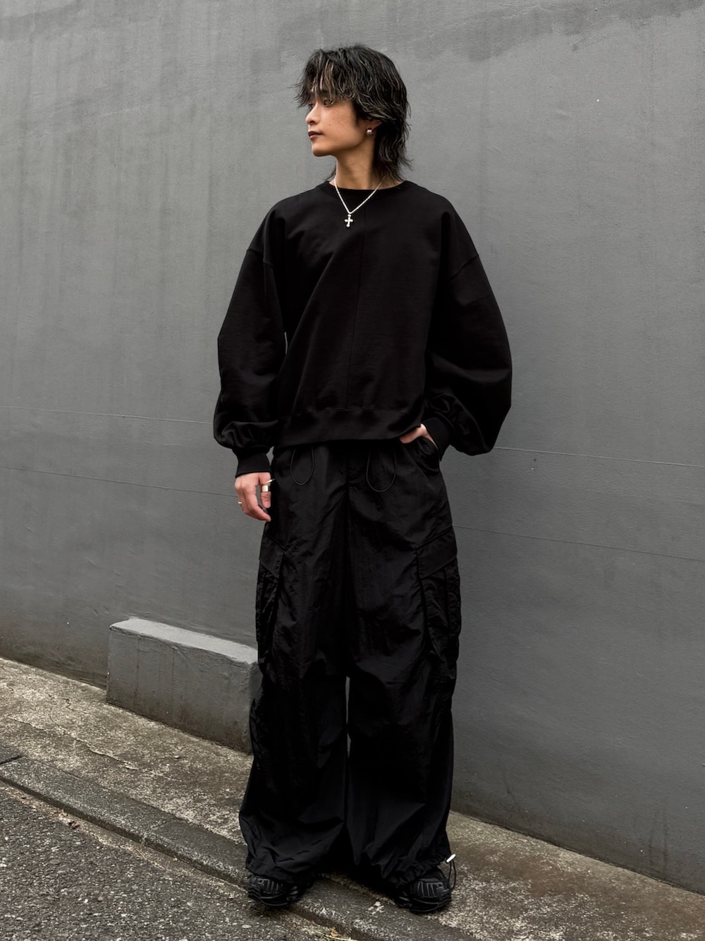 ブラック系のパーカー、ブラック系のカーゴパンツ、ブラック系のスウェットを着用したメンズの冬コーディネートの9枚目の写真