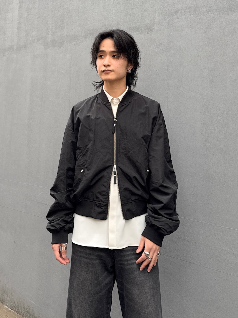 ブラック系のデニムパンツ、ホワイト系のシャツ/ブラウス、ブラック系のMA-1を着用したメンズの春コーディネートの4枚目の写真