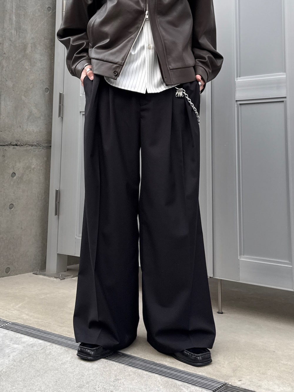 ブラウン系のブルゾン、ホワイト系のシャツ/ブラウス、ブラック系のスラックスを着用したメンズの春コーディネートの6枚目の写真