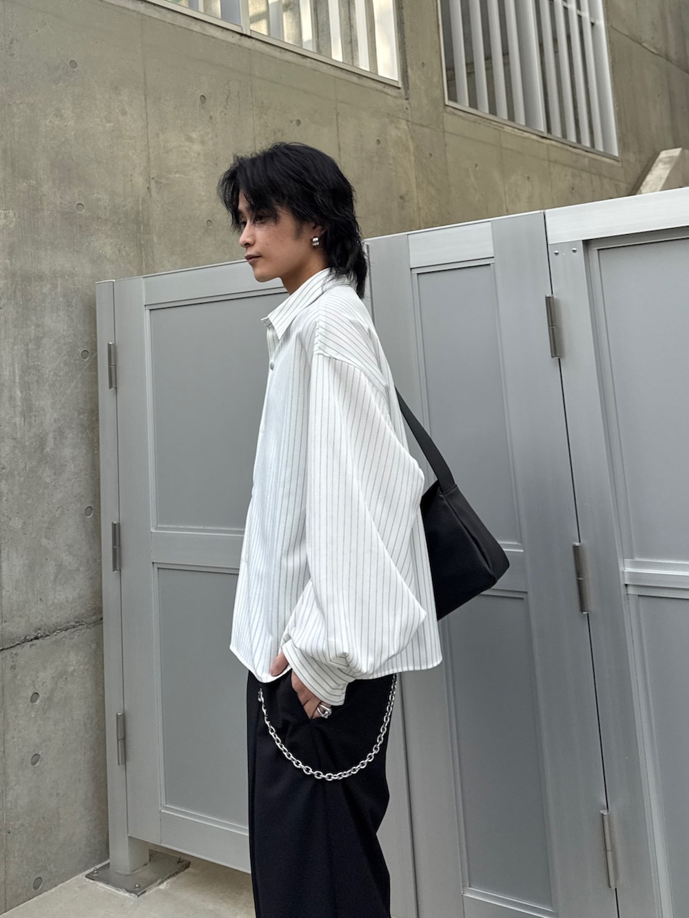 ホワイト系のシャツ/ブラウス、ブラック系のスラックス、ブラック系のショルダーバッグを着用したメンズの春コーディネートの5枚目の写真