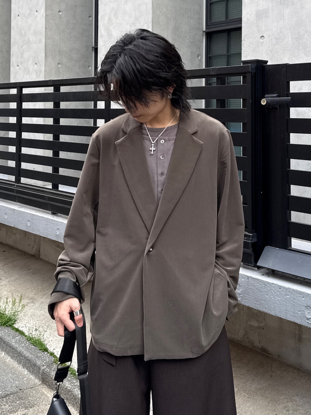 グレー系のTシャツ/カットソー、グレー系のスラックス、グリーン系のテーラードジャケットを着用したメンズの春コーディネートの4枚目の写真