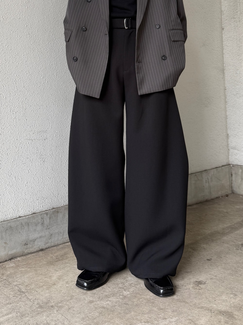 グレー系のテーラードジャケット、ブラック系のTシャツ/カットソー、ブラック系のスラックスを着用したメンズの春コーディネートの9枚目の写真