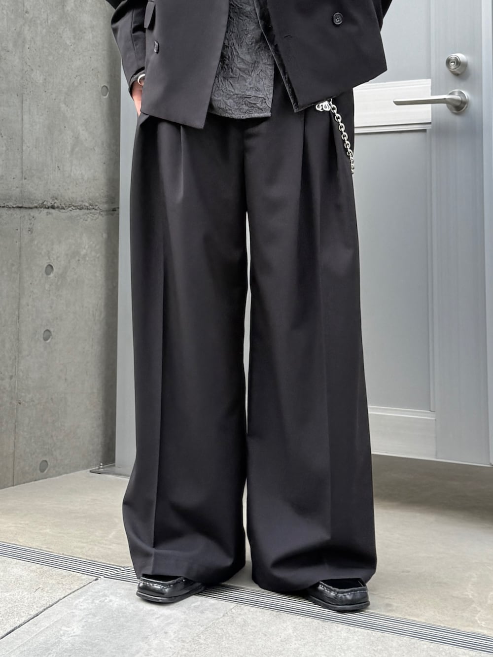 ブラック系のテーラードジャケット、ブラック系のシャツ/ブラウス、ブラック系のスラックスを着用したメンズの春コーディネートの7枚目の写真