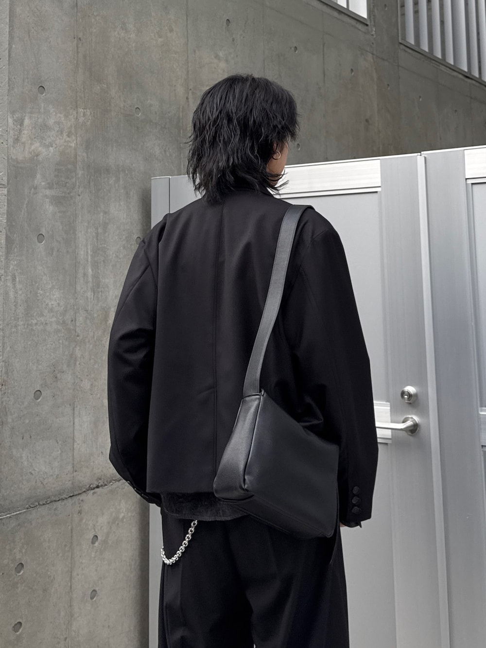 ブラック系のテーラードジャケット、ブラック系のシャツ/ブラウス、ブラック系のスラックスを着用したメンズの春コーディネートの6枚目の写真