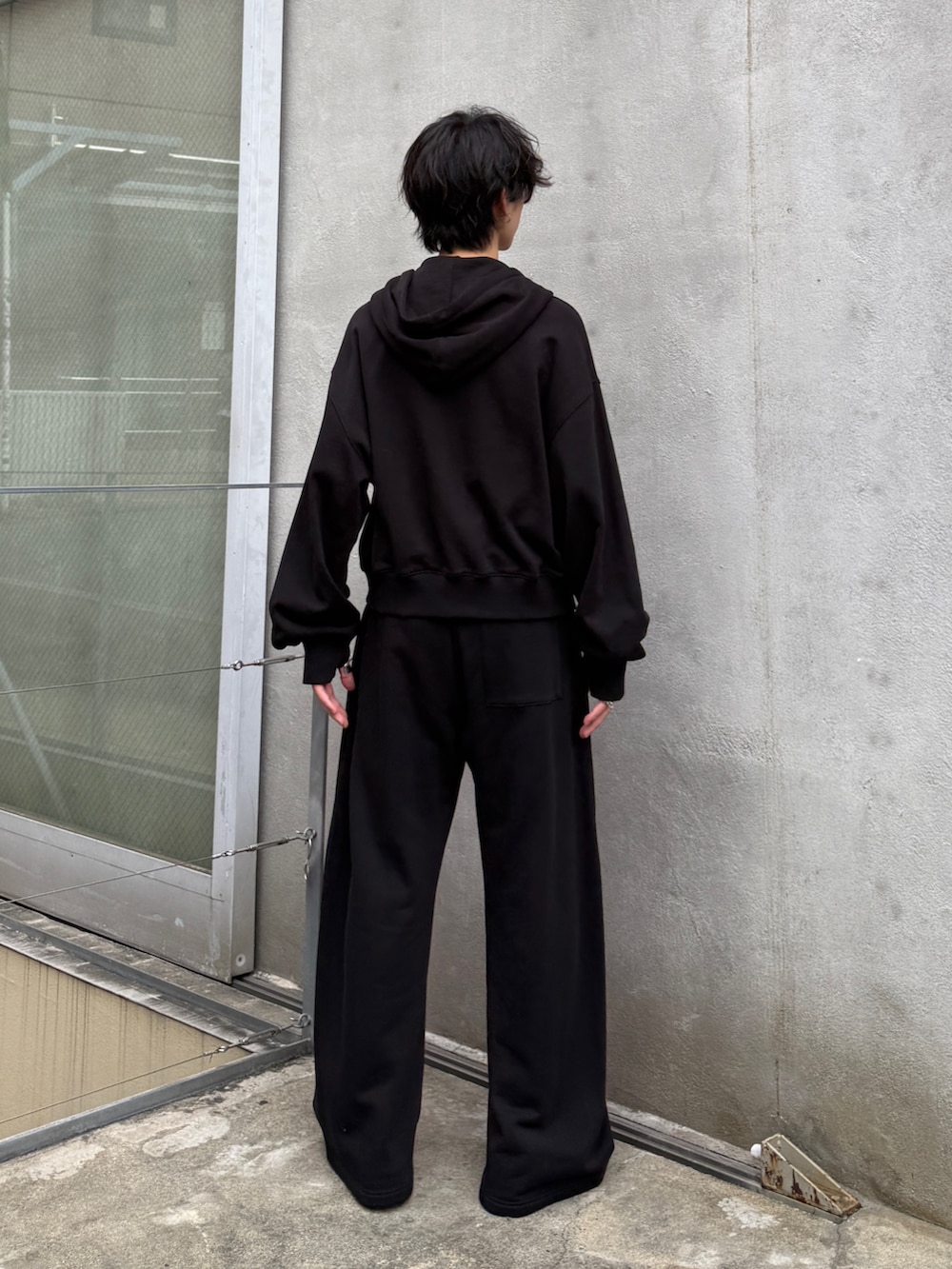 ブラック系のパーカー、ブラック系のスウェットパンツを着用したメンズの秋コーディネートの3枚目の写真