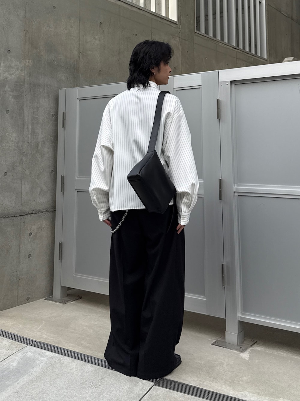 ホワイト系のシャツ/ブラウス、ブラック系のスラックス、ブラック系のショルダーバッグを着用したメンズの春コーディネートの3枚目の写真