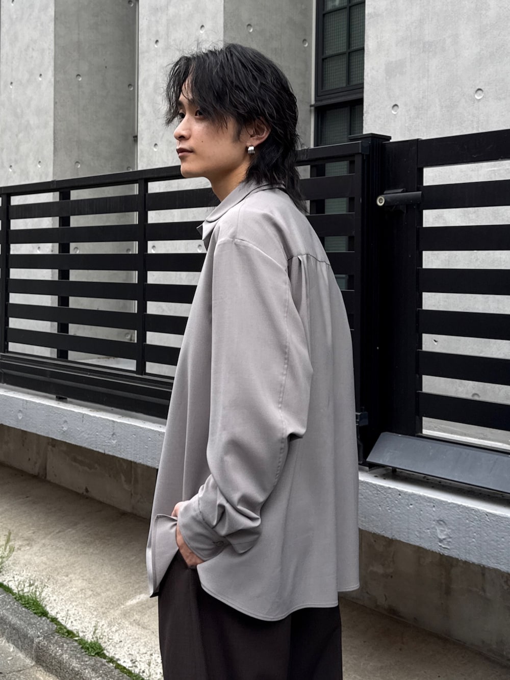 グレー系のシャツ/ブラウス、グレー系のスラックス、ブラック系のショルダーバッグを着用したメンズの春コーディネートの5枚目の写真
