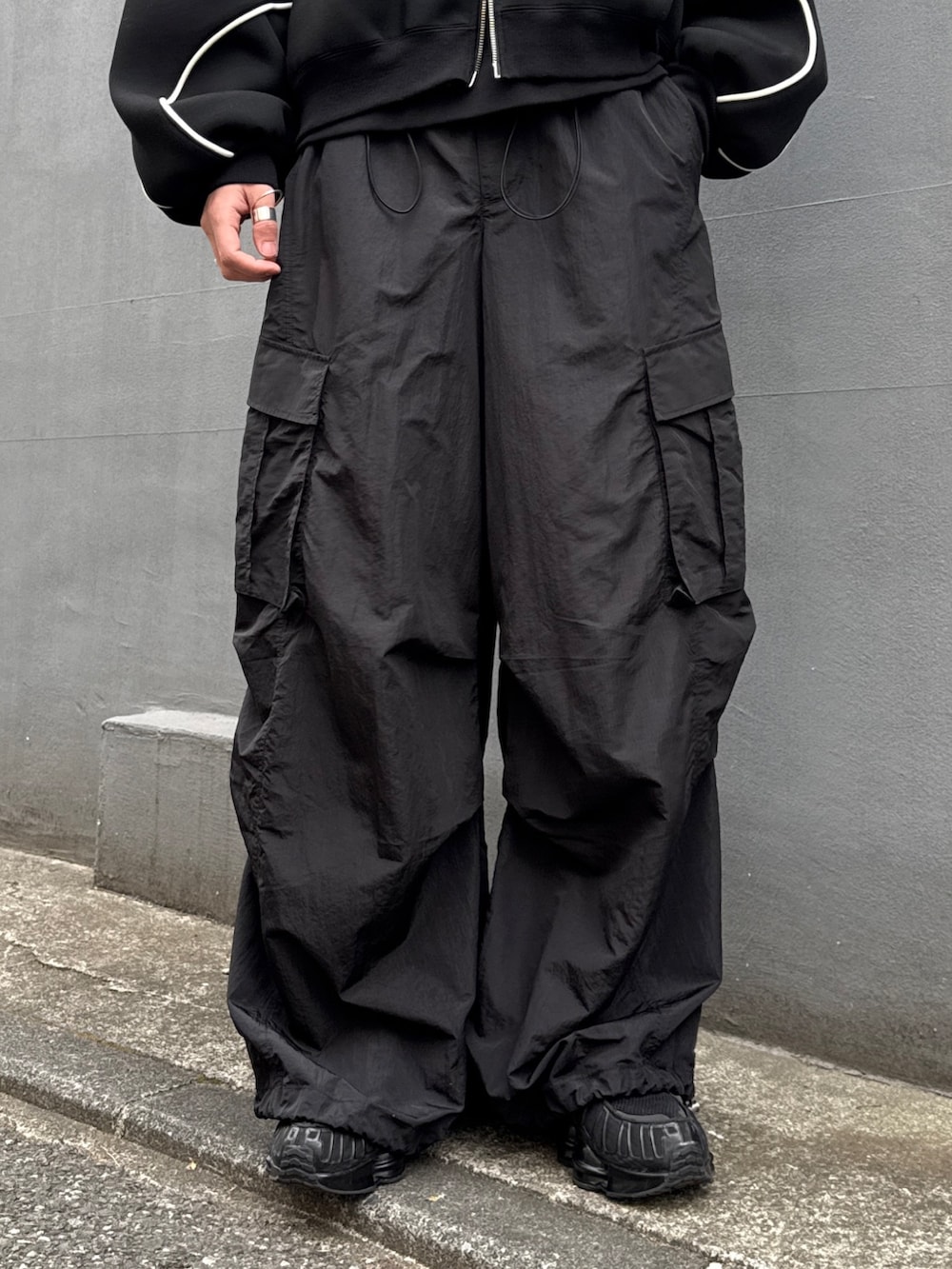 ブラック系のパーカー、ブラック系のカーゴパンツ、ブラック系のスウェットを着用したメンズの冬コーディネートの7枚目の写真