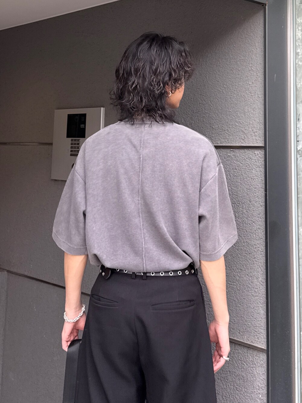 グレー系のTシャツ/カットソー、ブラック系のショルダーバッグ、ブラック系のスラックスを着用したメンズの春コーディネートの7枚目の写真