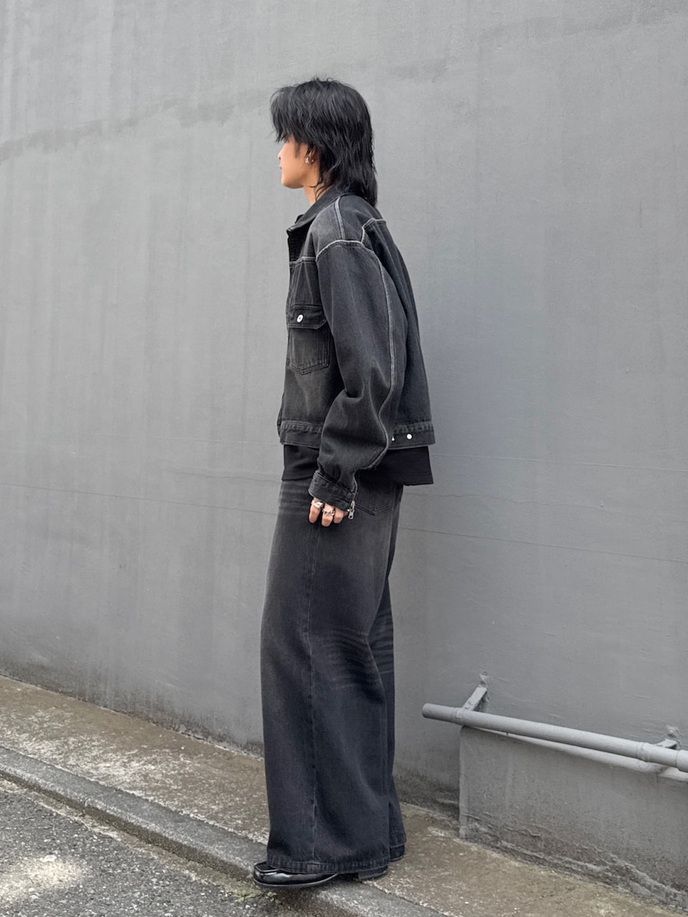 ブラック系のデニムジャケット、ブラック系のデニムパンツ、ブラック系のTシャツ/カットソーを着用したメンズの春コーディネートの2枚目の写真