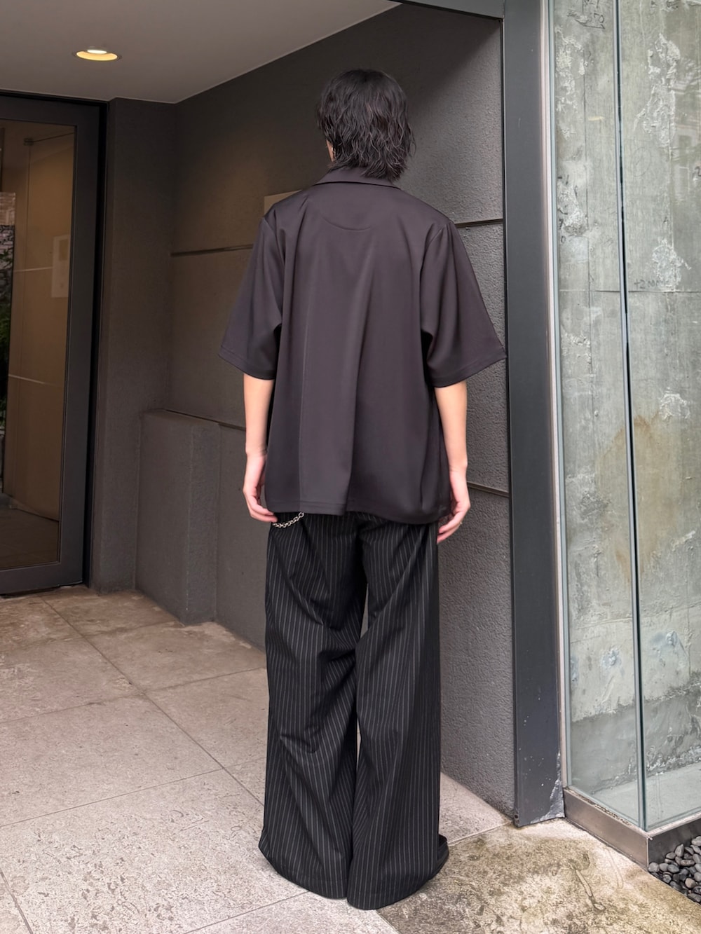 ブラック系のシャツ/ブラウス、ブラック系のTシャツ/カットソー、ブラック系のスラックスを着用したメンズの夏コーディネートの3枚目の写真
