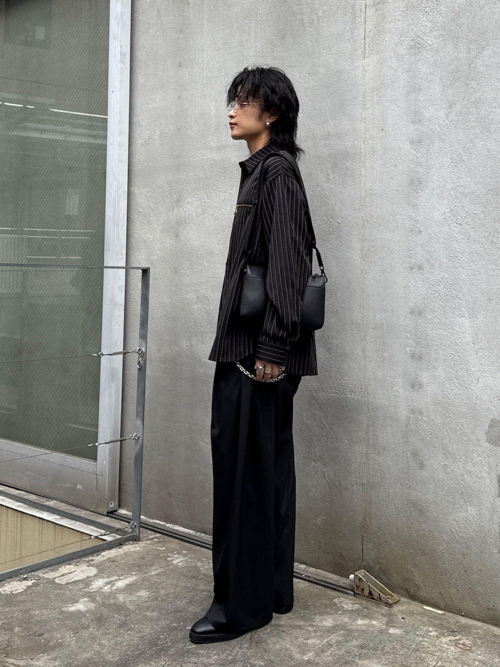 ブラック系のその他パンツ、ブラック系のショルダーバッグ、ブラック系のシャツ/ブラウスを着用したメンズの春コーディネートの2枚目の写真