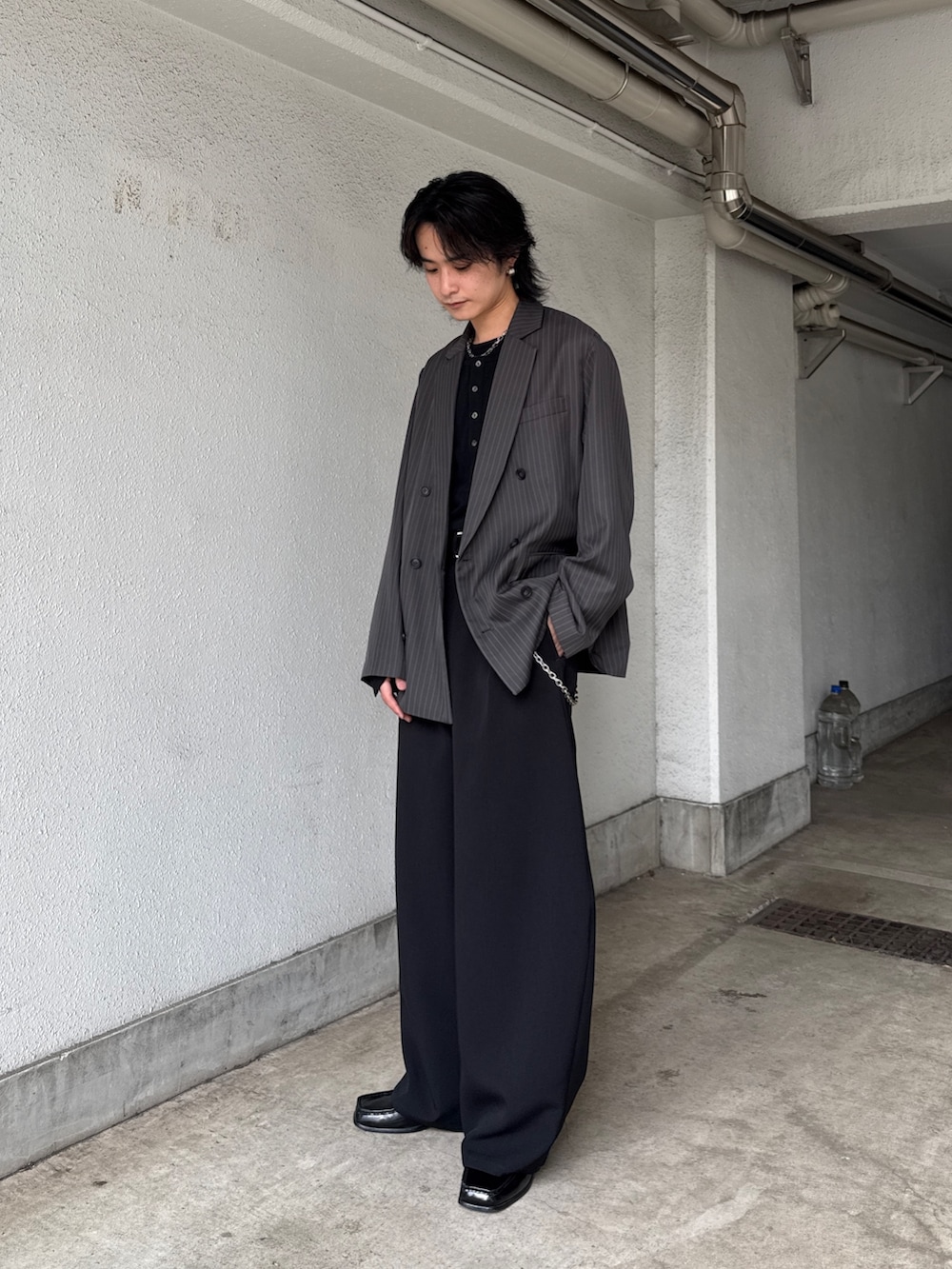 グレー系のテーラードジャケット、ブラック系のTシャツ/カットソー、ブラック系のスラックスを着用したメンズの春コーディネートの2枚目の写真