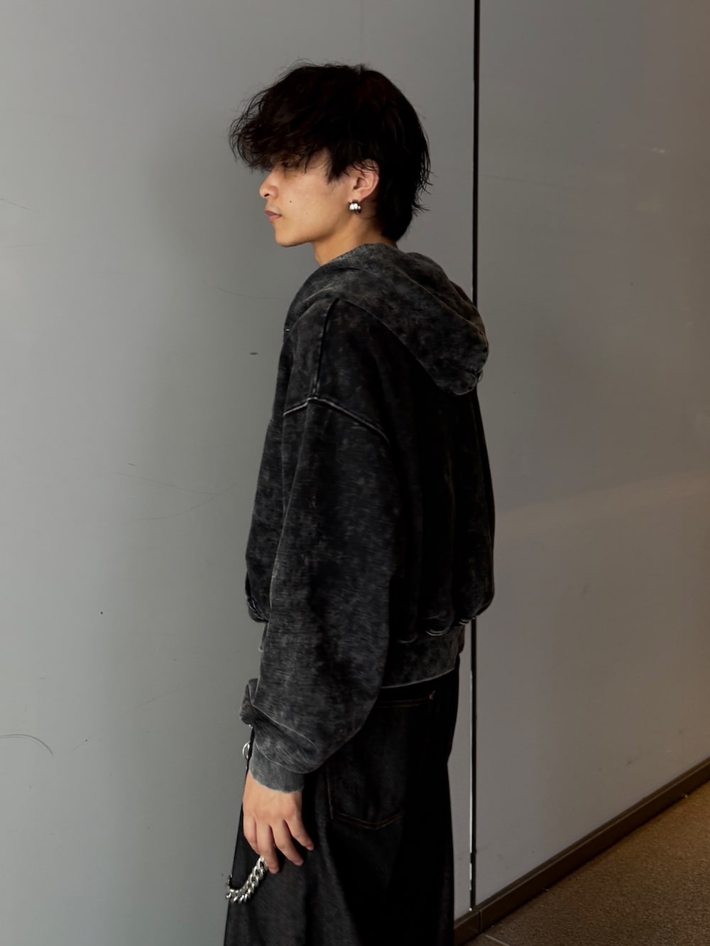 ブラック系のパーカー、ブラック系のデニムパンツを着用したメンズの秋コーディネートの4枚目の写真