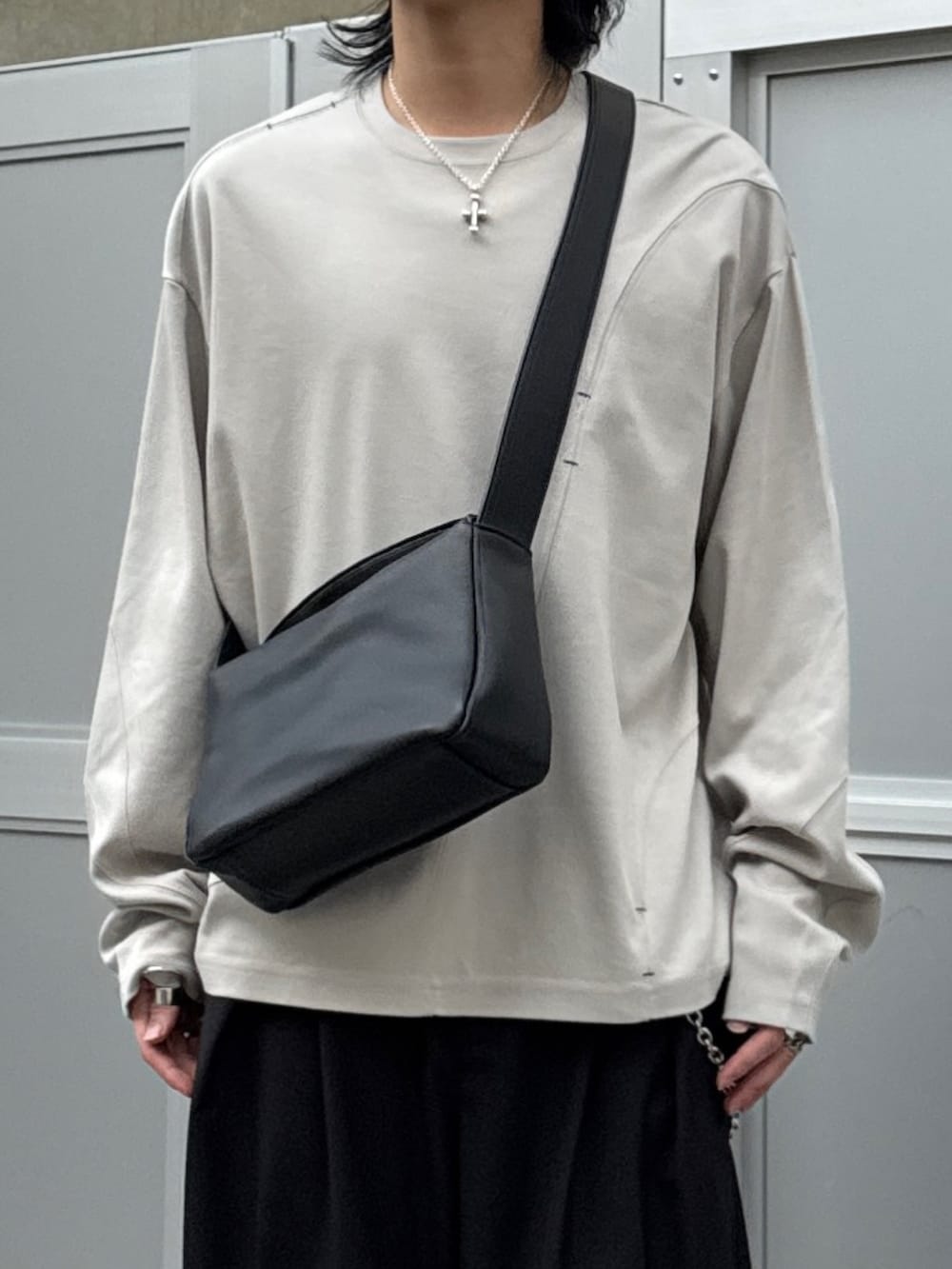 グレー系のTシャツ/カットソー、ブラック系のショルダーバッグ、ブラック系のスラックスを着用したメンズの春コーディネートの3枚目の写真