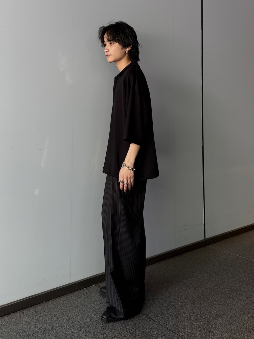 ブラック系のTシャツ/カットソー、グレー系のスラックスを着用したメンズの夏コーディネートの2枚目の写真