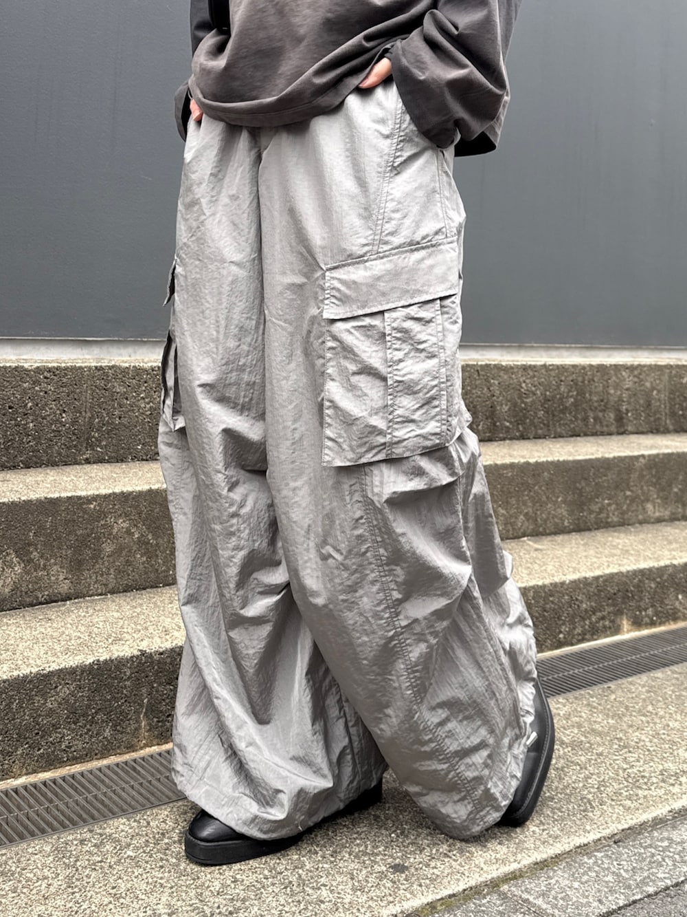 ブラック系のTシャツ/カットソー、グレー系のカーゴパンツ、ブラック系のショルダーバッグを着用したメンズの春コーディネートの8枚目の写真