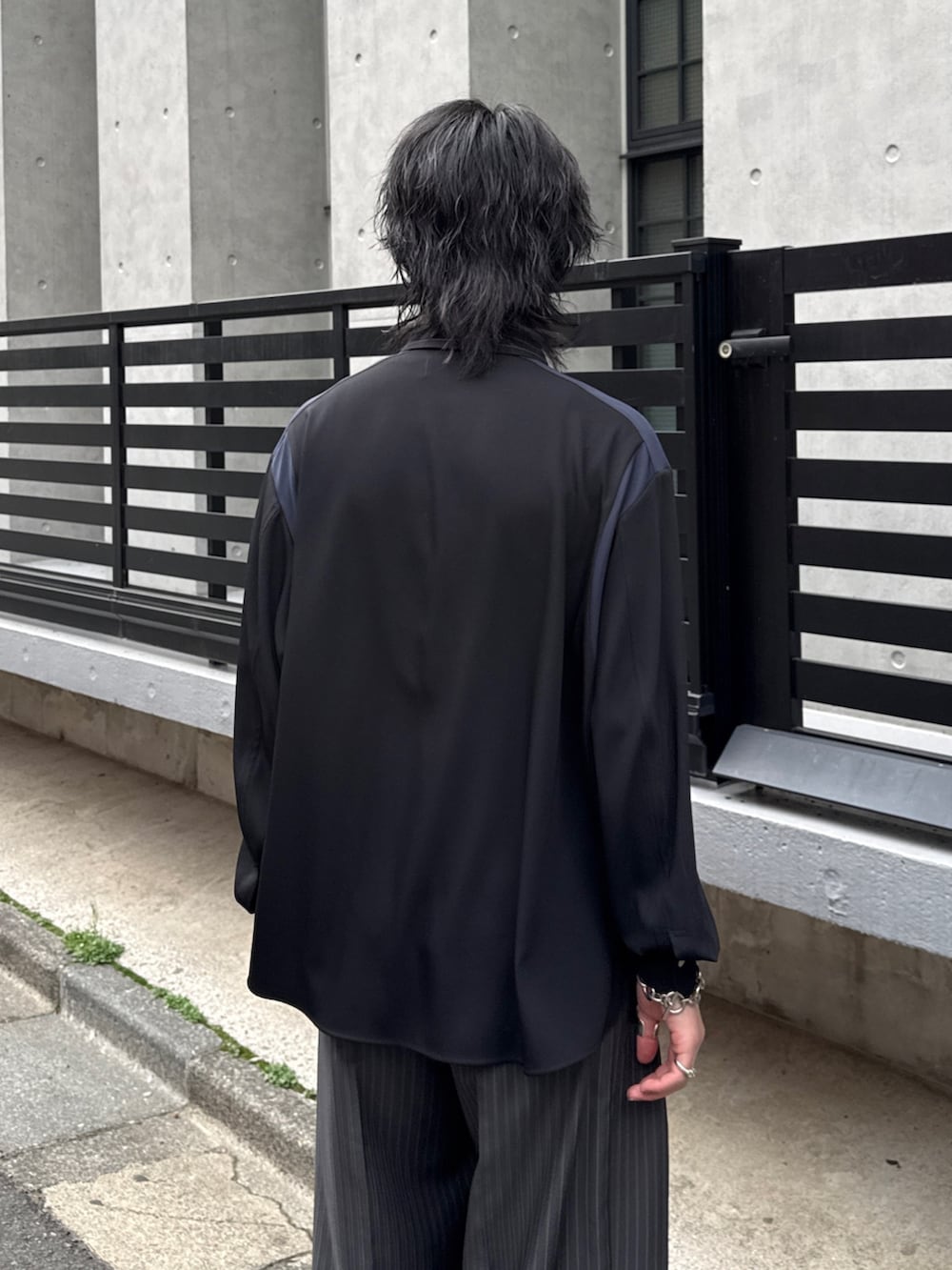 グレー系のスラックス、グレー系のテーラードジャケット、ブラック系のシャツ/ブラウスを着用したメンズの春コーディネートの7枚目の写真