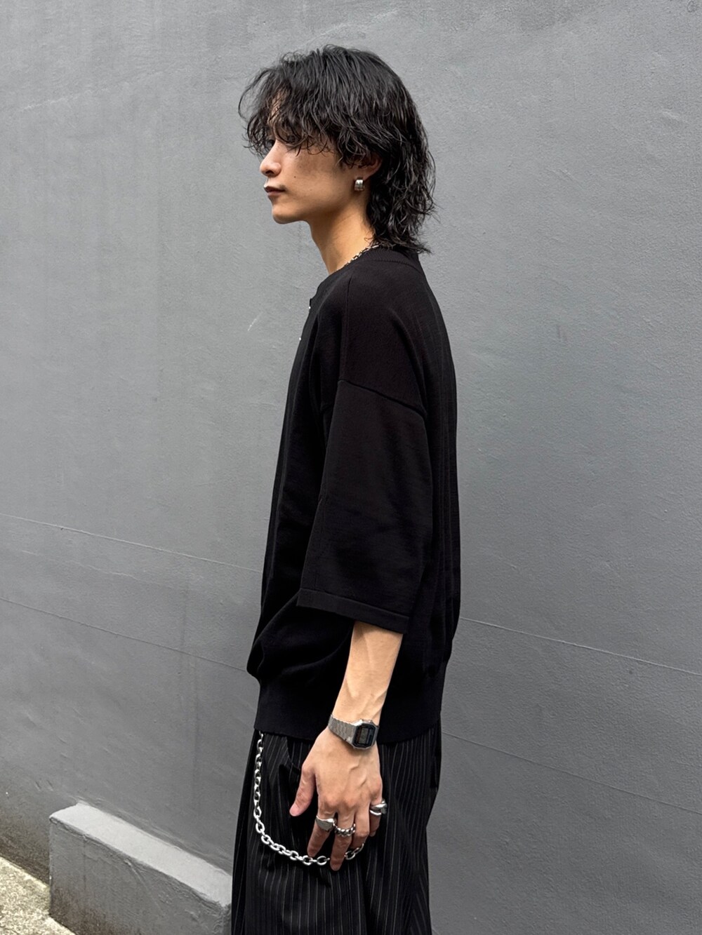 ブラック系のTシャツ/カットソー、ブラック系のスラックス、シルバー系のウォレットチェーンを着用したメンズの夏コーディネートの5枚目の写真