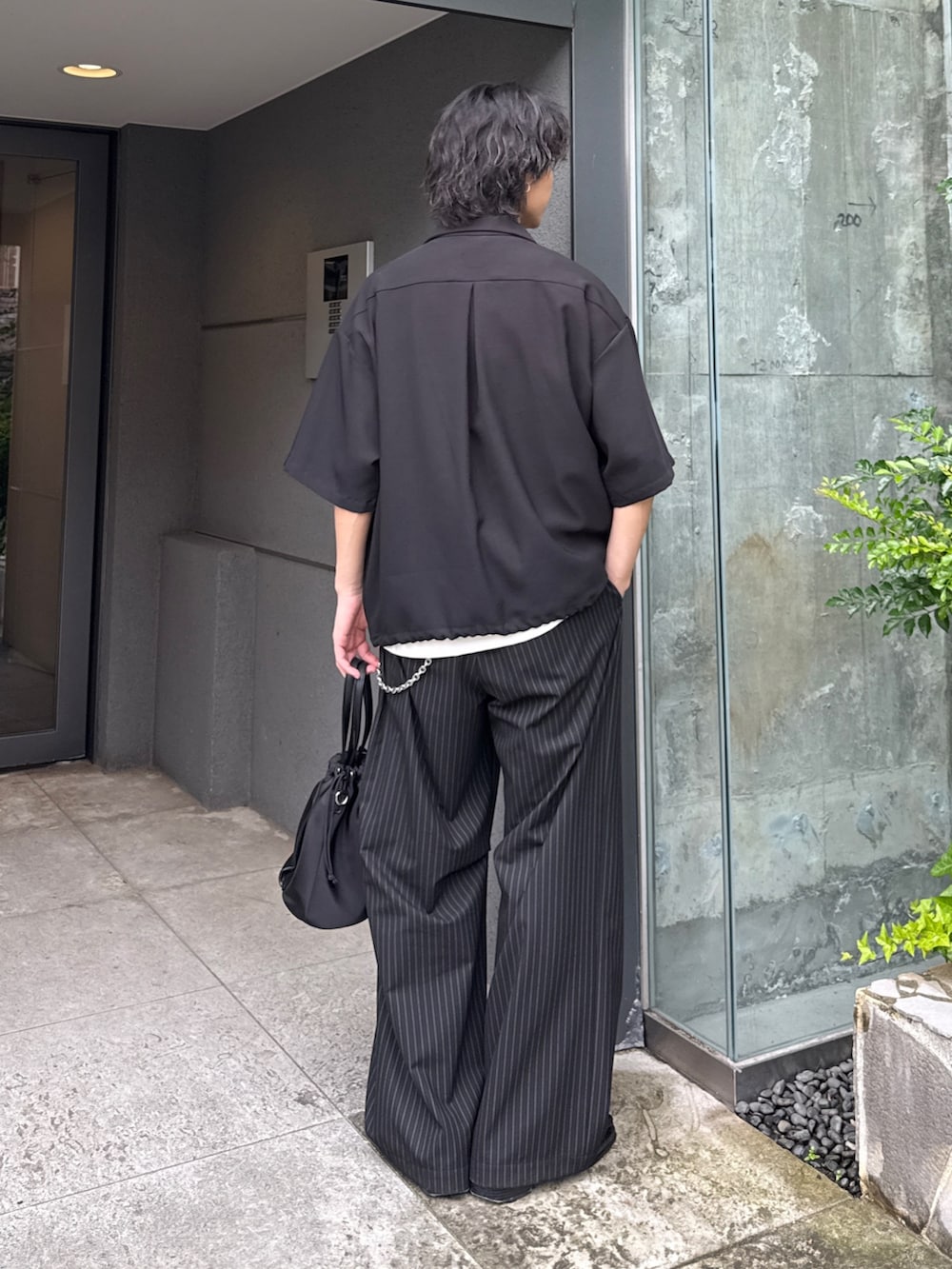 ブラック系のシャツ/ブラウス、ブラック系のスラックス、ブラック系のショルダーバッグを着用したメンズの夏コーディネートの3枚目の写真