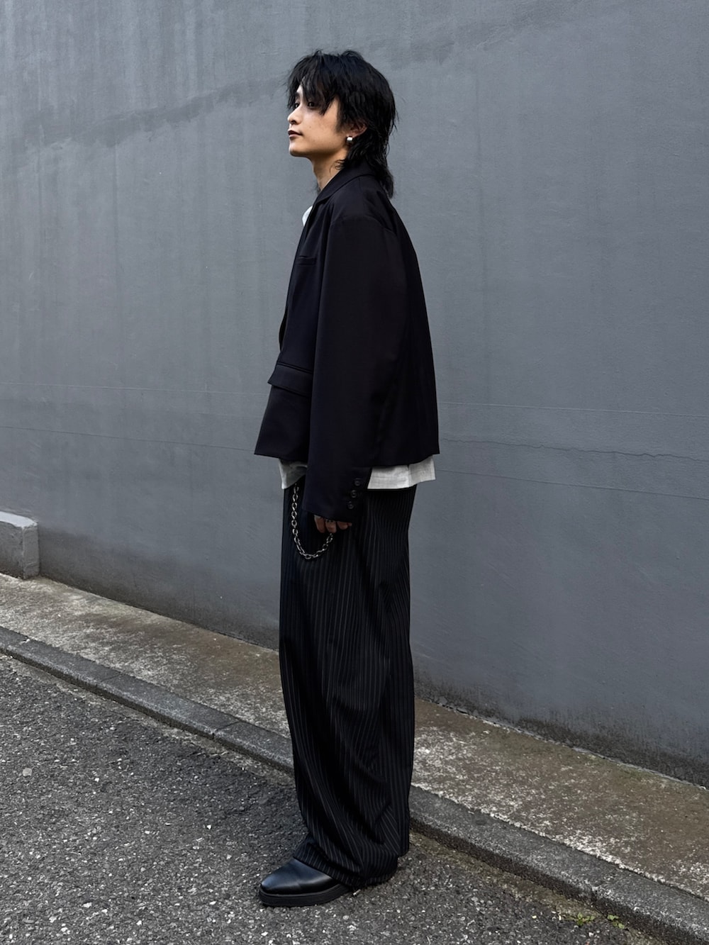 ブラック系のテーラードジャケット、グレー系のシャツ/ブラウス、ブラック系のスラックスを着用したメンズの春コーディネートの2枚目の写真