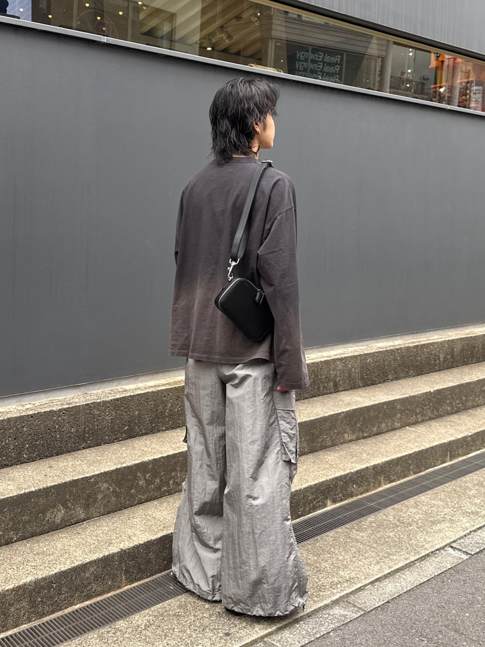 ブラック系のTシャツ/カットソー、グレー系のカーゴパンツ、ブラック系のショルダーバッグを着用したメンズの春コーディネートの3枚目の写真