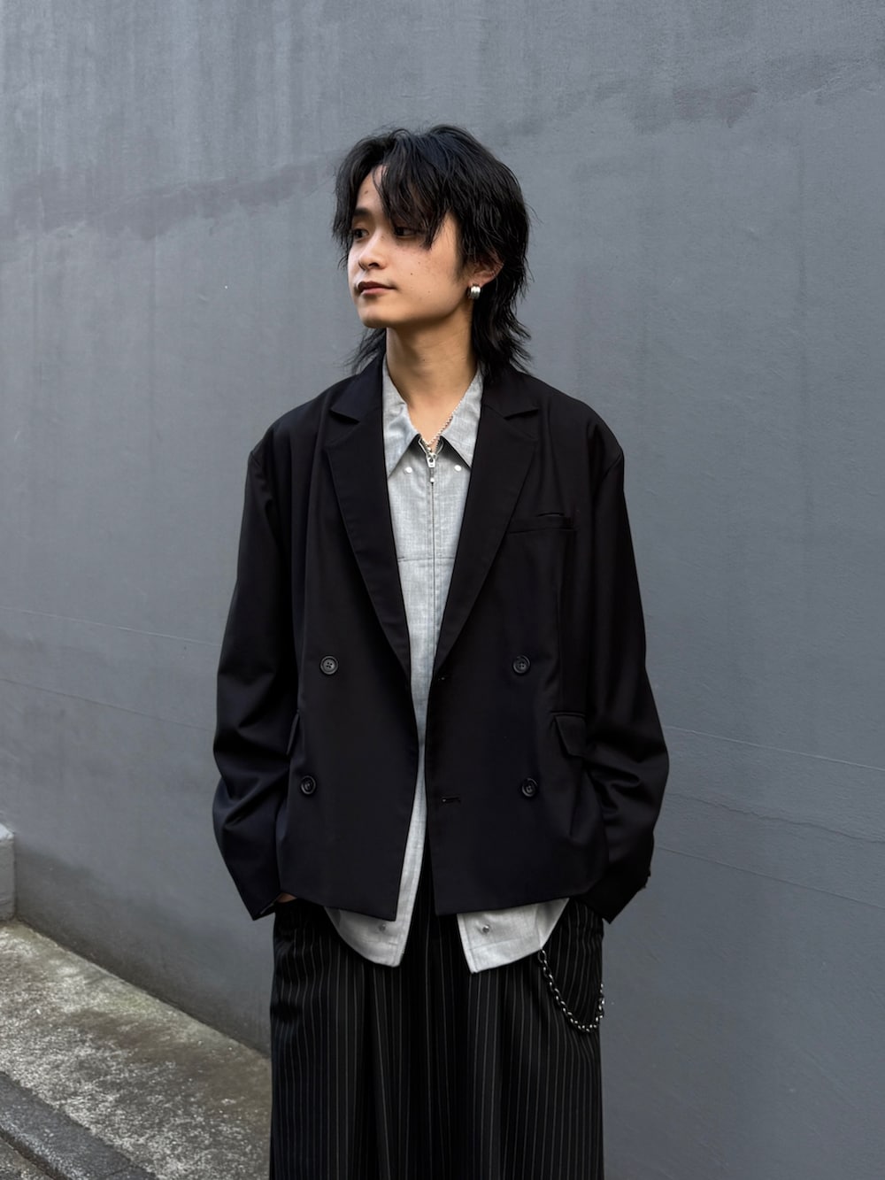 ブラック系のテーラードジャケット、グレー系のシャツ/ブラウス、ブラック系のスラックスを着用したメンズの春コーディネートの4枚目の写真