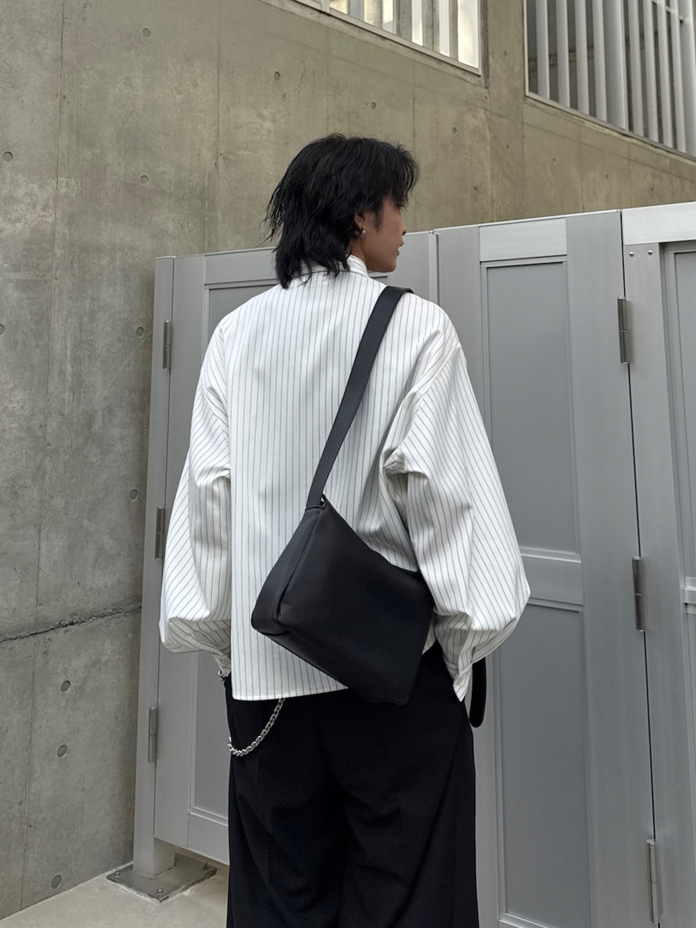 ホワイト系のシャツ/ブラウス、ブラック系のスラックス、ブラック系のショルダーバッグを着用したメンズの春コーディネートの6枚目の写真