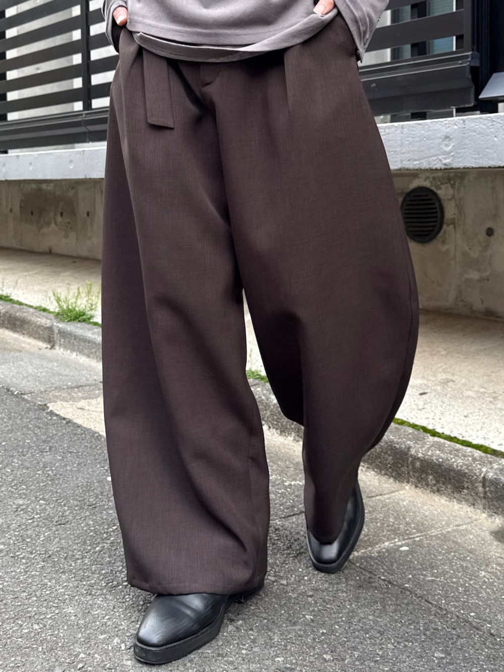 グレー系のTシャツ/カットソー、グレー系のスラックス、グリーン系のテーラードジャケットを着用したメンズの春コーディネートの10枚目の写真