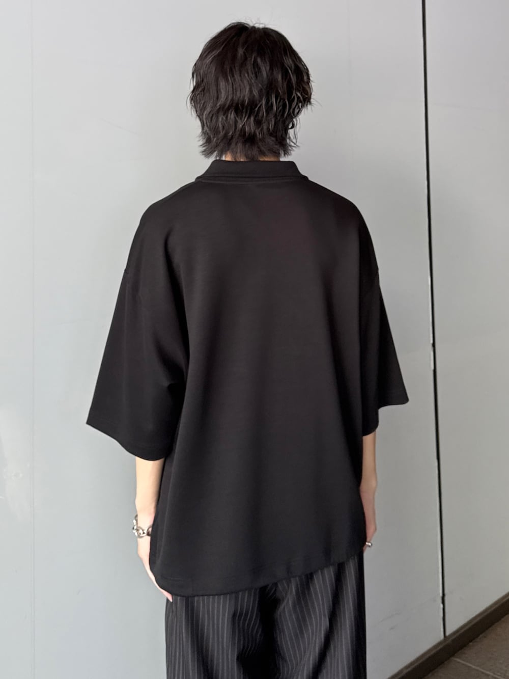 ブラック系のTシャツ/カットソー、グレー系のスラックスを着用したメンズの夏コーディネートの5枚目の写真