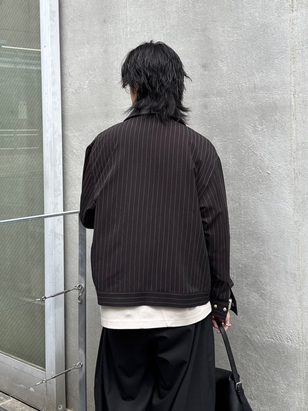 ブラック系のその他パンツ、ブラック系のハンドバッグ、グレー系のTシャツ/カットソーを着用したメンズの春コーディネートの6枚目の写真