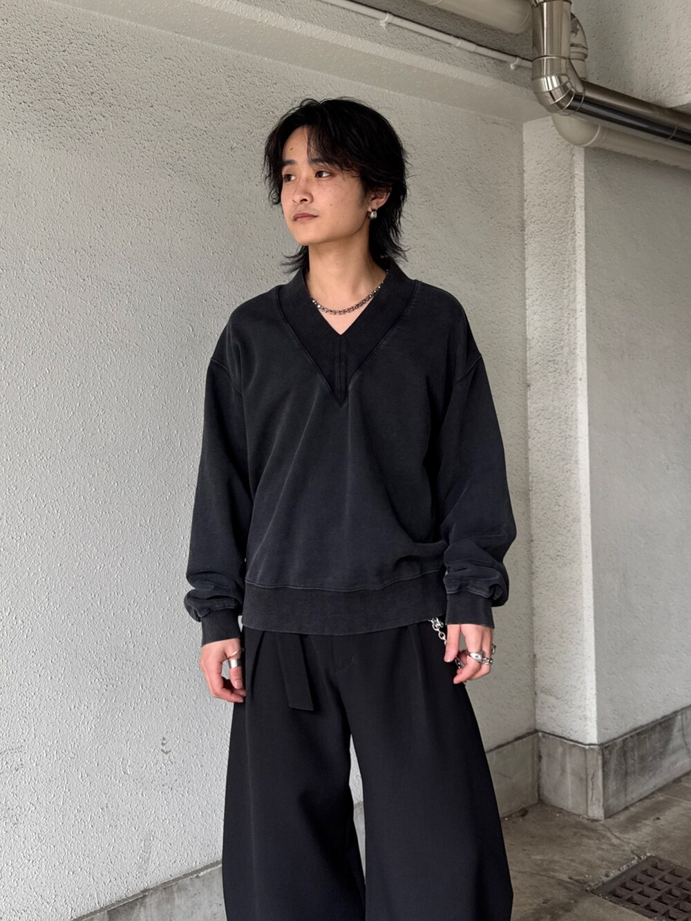 ブラック系のスウェット、ブラック系のスラックス、シルバー系のネックレスを着用したメンズの春コーディネートの4枚目の写真