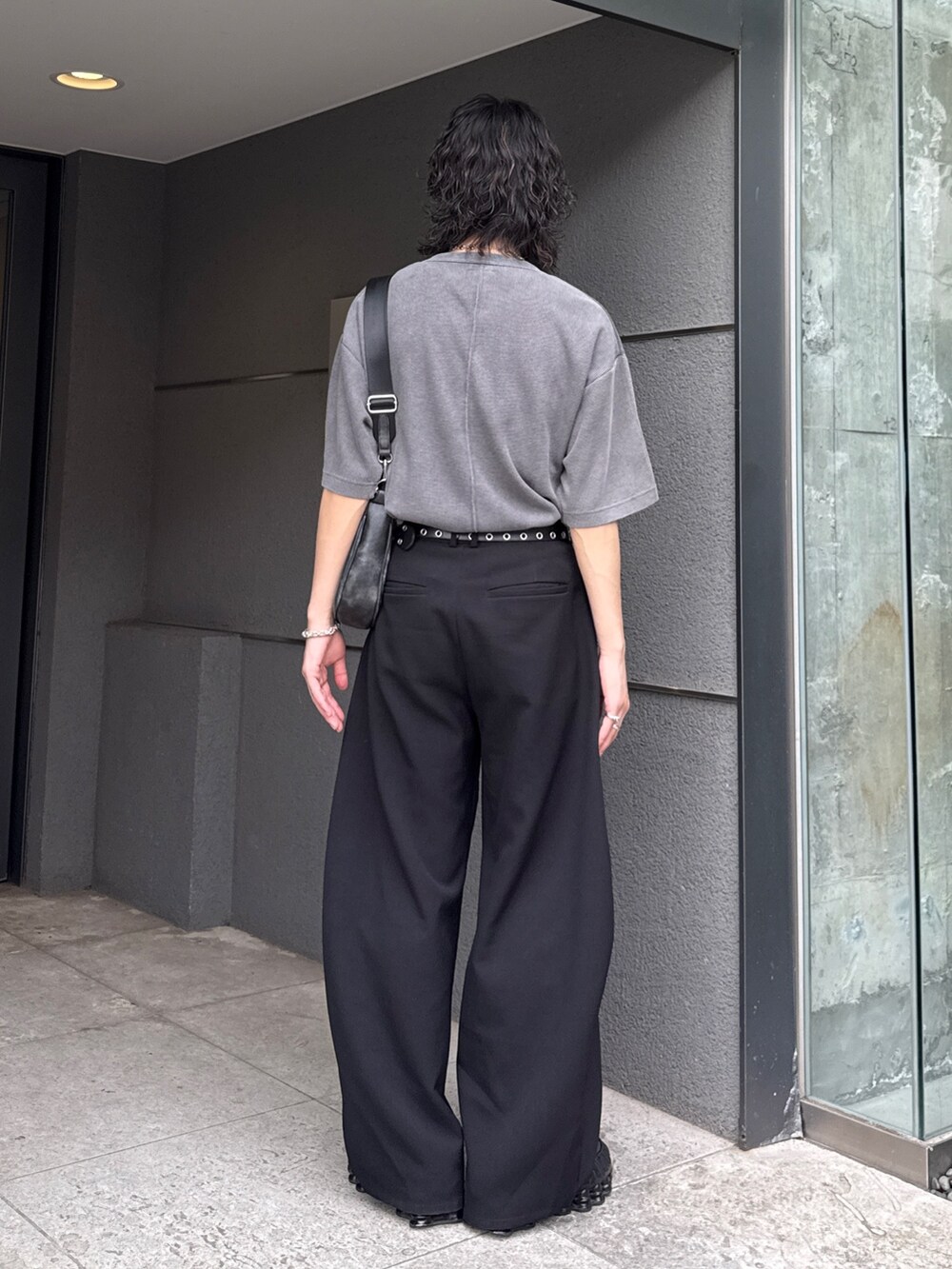 グレー系のTシャツ/カットソー、ブラック系のショルダーバッグ、ブラック系のスラックスを着用したメンズの春コーディネートの4枚目の写真