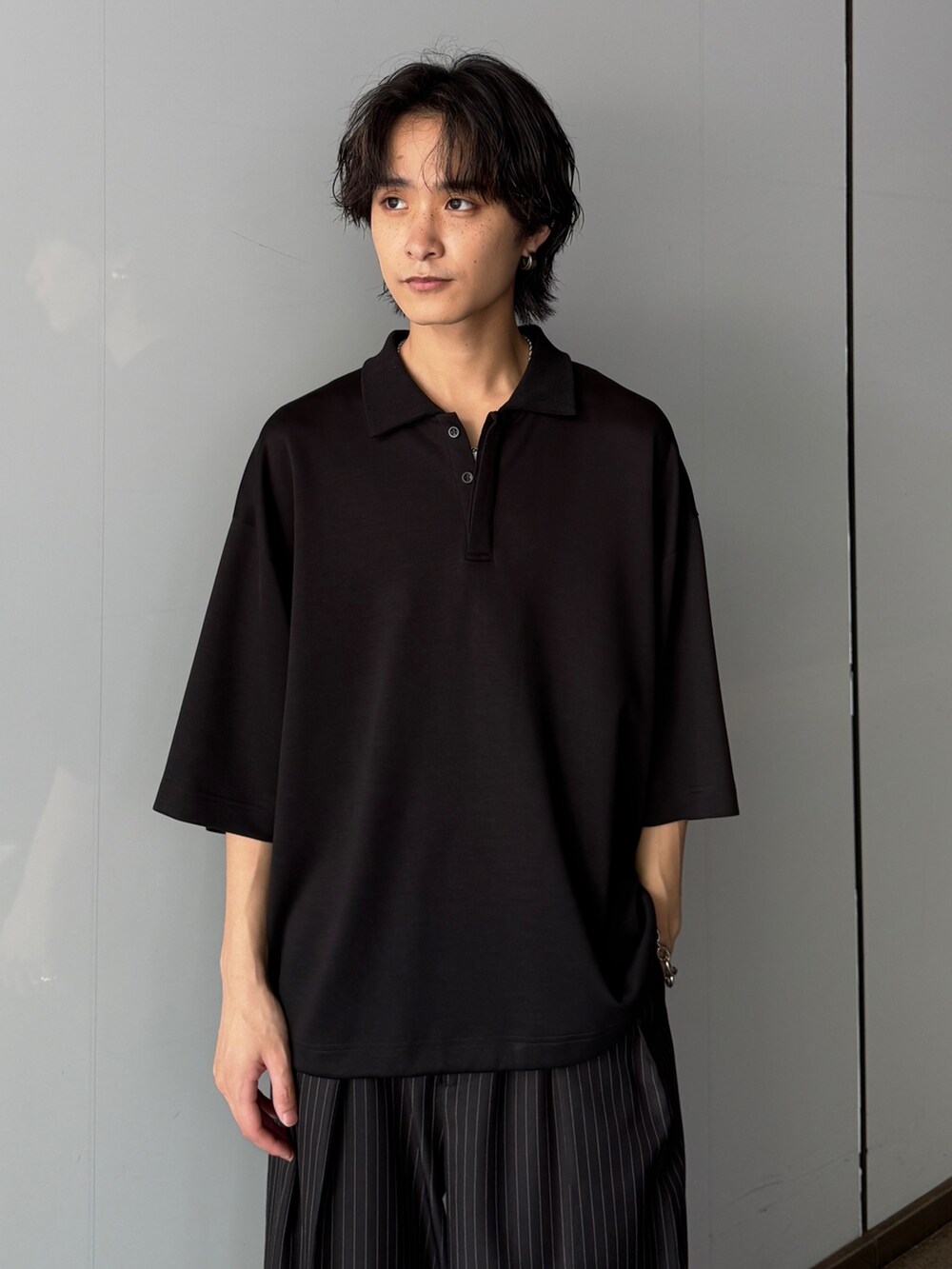 ブラック系のTシャツ/カットソー、グレー系のスラックスを着用したメンズの夏コーディネートの4枚目の写真