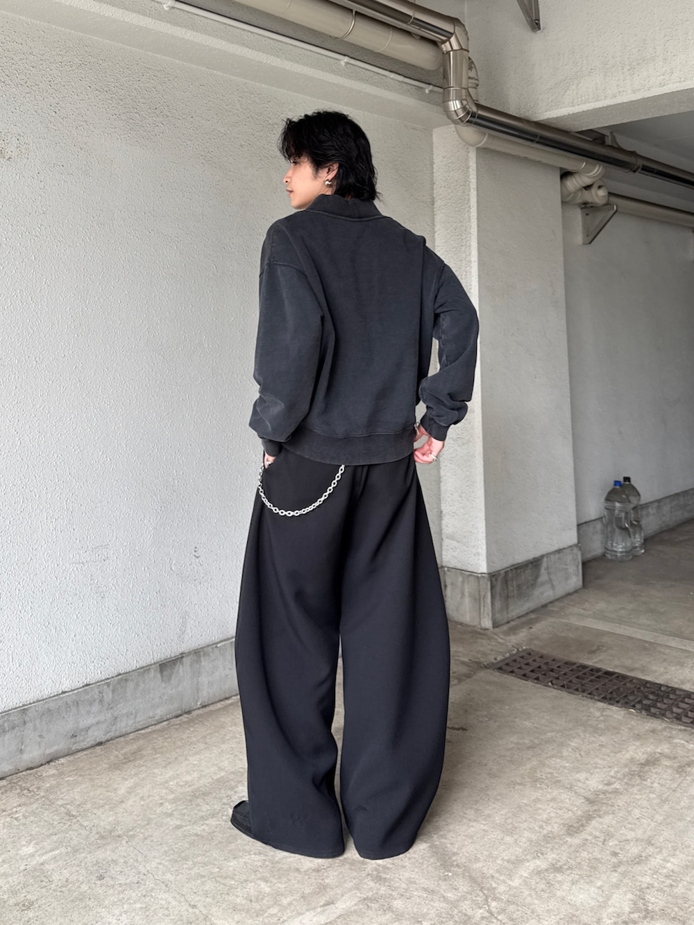 ブラック系のスウェット、ブラック系のスラックス、シルバー系のネックレスを着用したメンズの春コーディネートの3枚目の写真