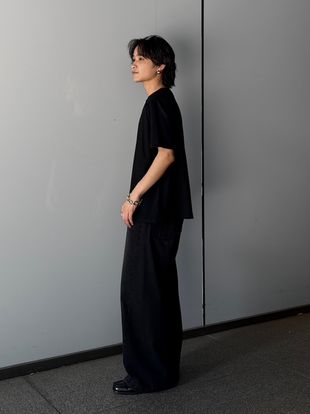 ブラック系のTシャツ/カットソー、ブラック系のデニムパンツを着用したメンズの夏コーディネートの2枚目の写真