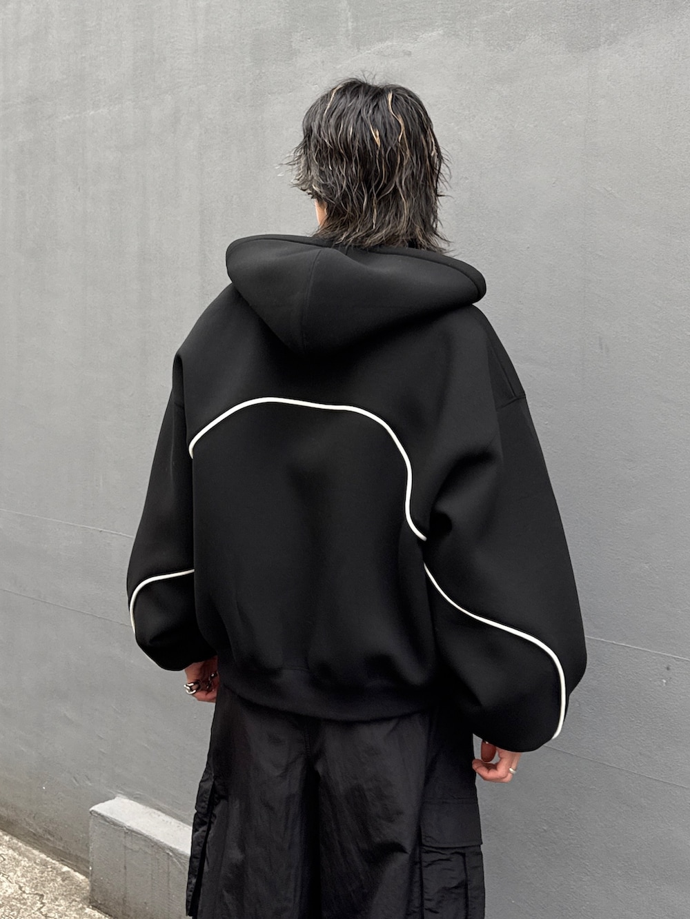 ブラック系のパーカー、ブラック系のカーゴパンツ、ブラック系のスウェットを着用したメンズの冬コーディネートの6枚目の写真