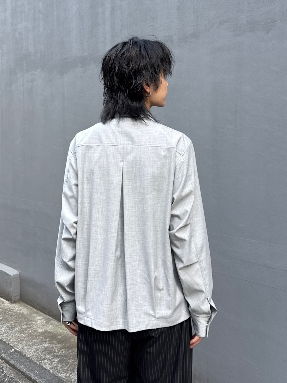 ブラック系のテーラードジャケット、グレー系のシャツ/ブラウス、ブラック系のスラックスを着用したメンズの春コーディネートの8枚目の写真