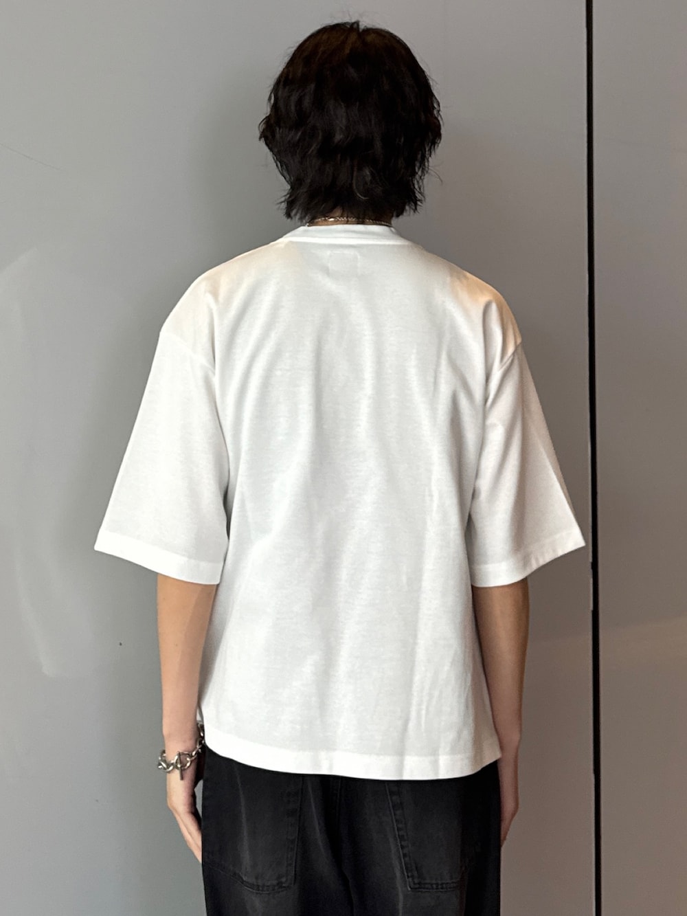 ホワイト系のTシャツ/カットソー、ブラック系のデニムパンツを着用したメンズの夏コーディネートの6枚目の写真