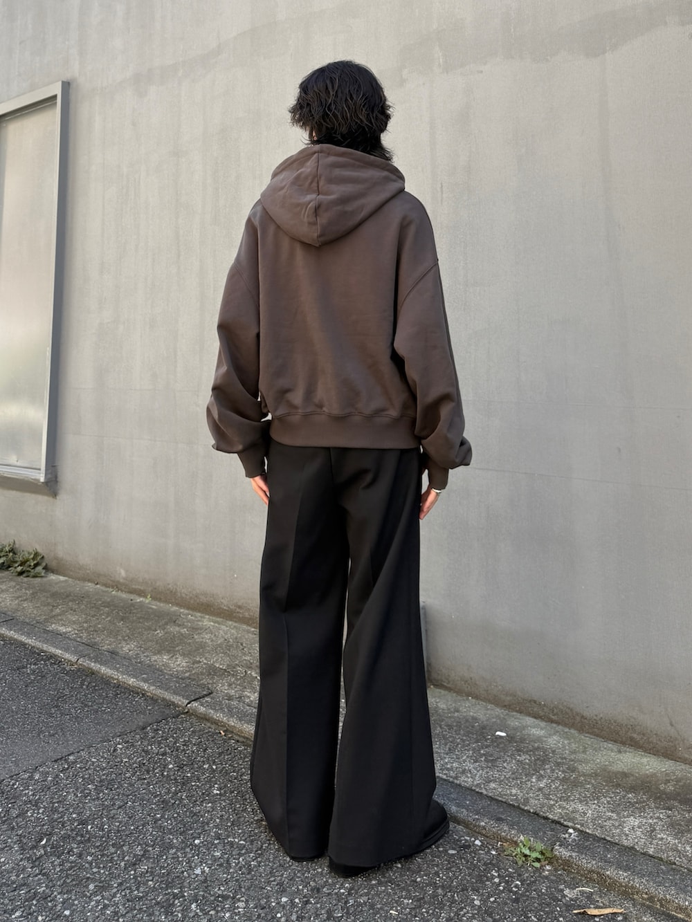 グレー系のパーカー、ブラック系のスラックスを着用したメンズの秋コーディネートの4枚目の写真