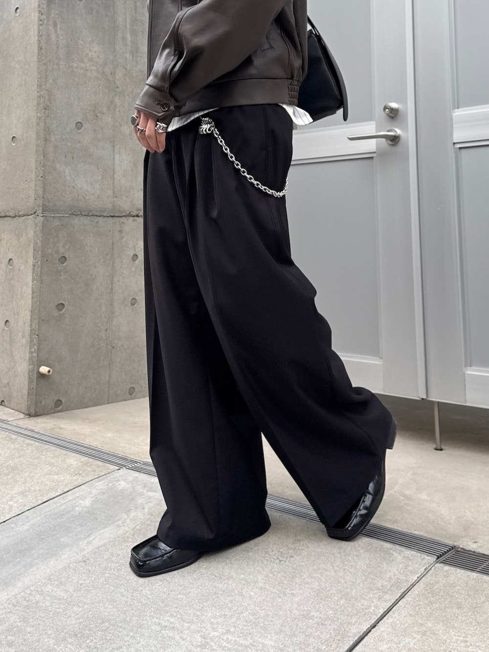 ブラウン系のブルゾン、ホワイト系のシャツ/ブラウス、ブラック系のスラックスを着用したメンズの春コーディネートの7枚目の写真