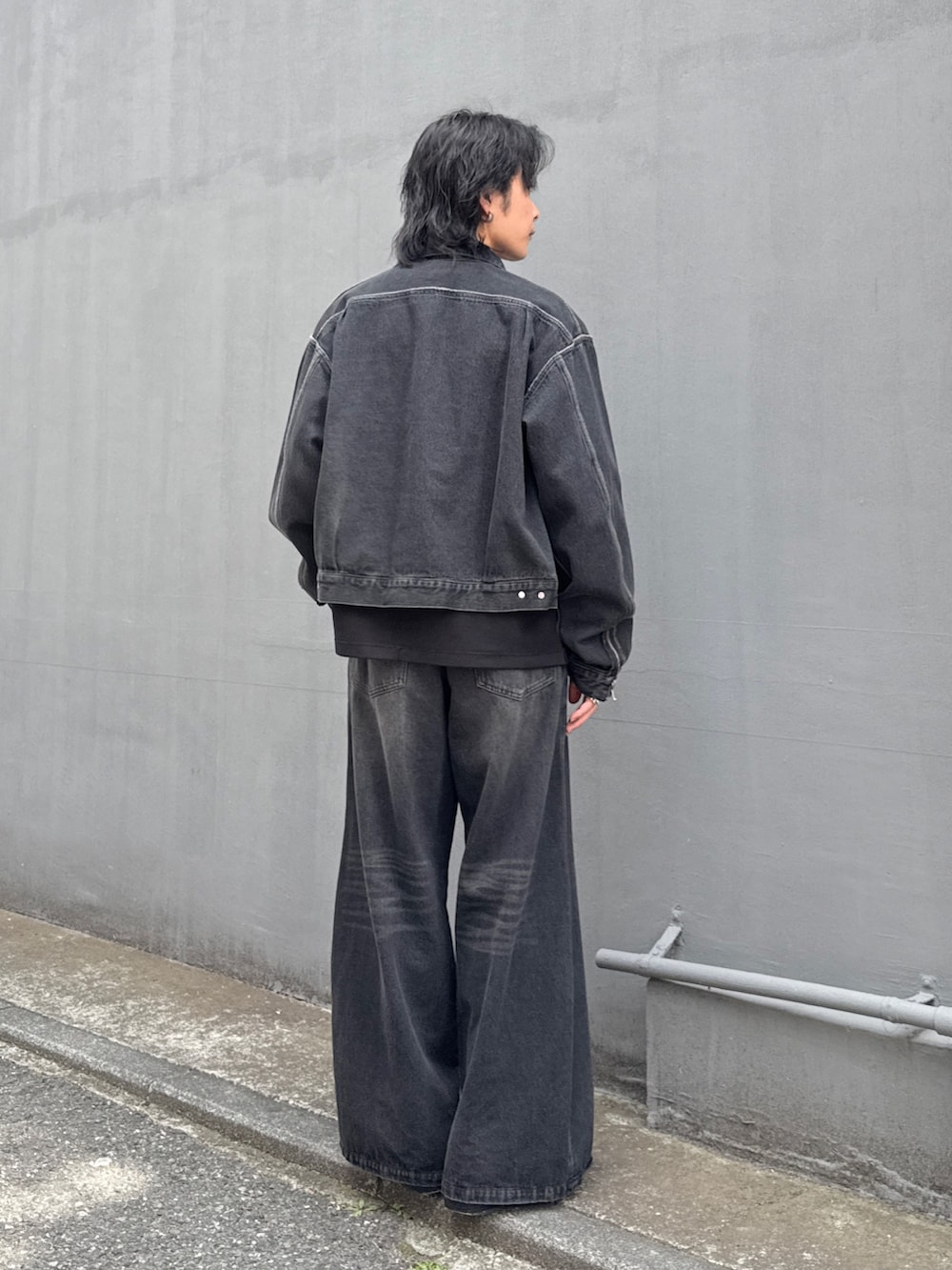 ブラック系のデニムジャケット、ブラック系のデニムパンツ、ブラック系のTシャツ/カットソーを着用したメンズの春コーディネートの3枚目の写真